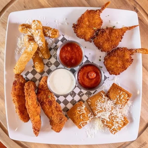 A Frends Brewhouse appetizer platter with fried shrimp, mozzarella sticks, chicken tenders, and ravioli.
