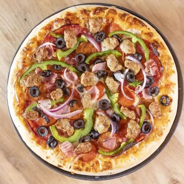 A Frends Brewhouse pizza with pepperoni, sausage, ham, green peppers, red onion, and black olives.