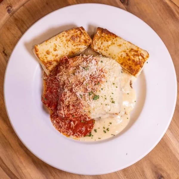 Frends Brewhouse's lasagna with red and white sauce, topped with cheese and parsley, served with garlic bread.
